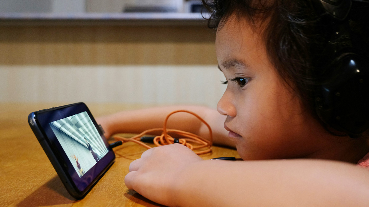 Un enfant regarde une vidéo sur un smarpthone. Un enfant regarde une vidéo sur un smarpthone.