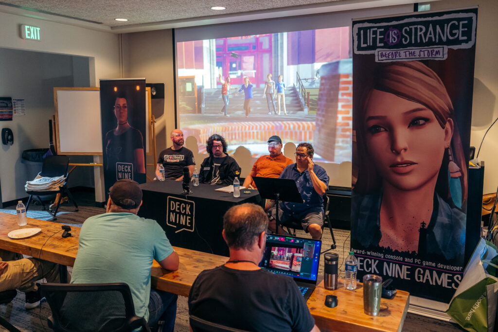 Photo de plusieurs membres de Deck Nine Games assis pour une confÃ©rence donnÃ©e Ã  l'Ã©cole RMCAD en 2023.