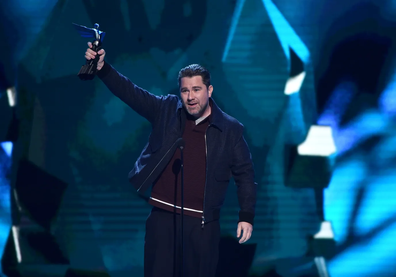 Roger Clark levant son trophée sur la scène des Game Awards 2018. Roger Clark levant son trophée sur la scène des Game Awards 2018.