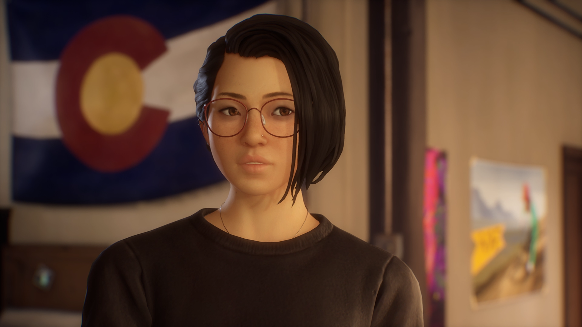 Plan serré sur Alex Chen, l'héroïne de Life is Strange True Colors. Elle porte un sweat noir, signe d'un deuil récent.