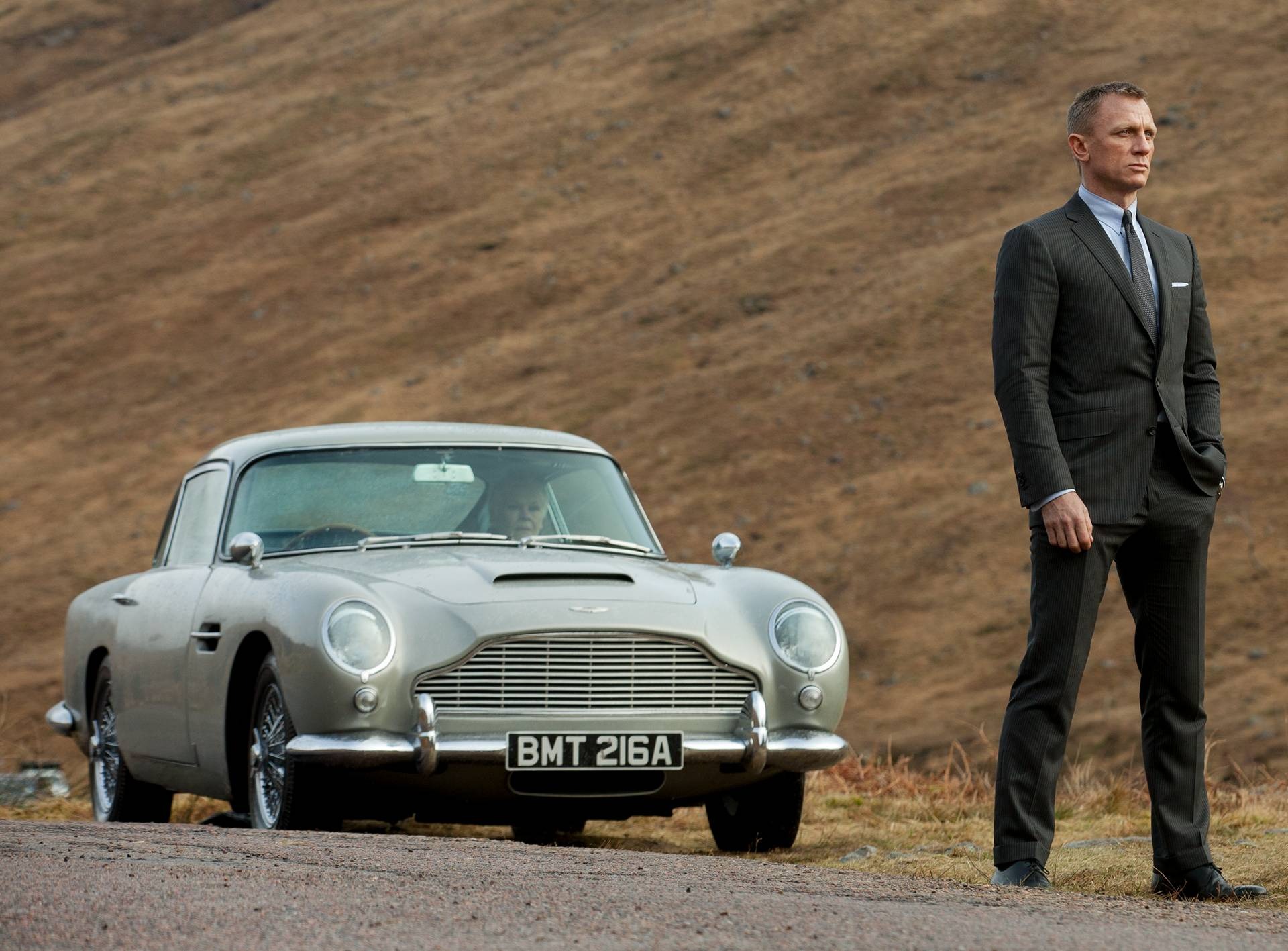 Image de James Bond (Daniel Craig) avec M (Judi Dench) au volant de l'Aston Martin DB5.