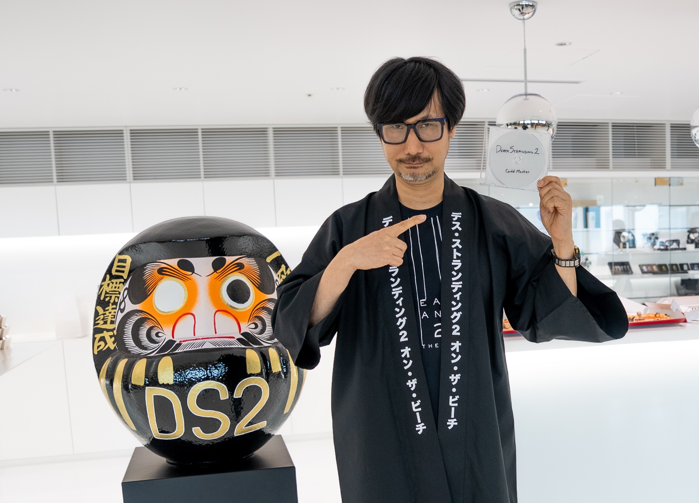 Image de la version gold de Death Stranding 2 On the Beach dans la main d'Hideo Kojima qui acte la fin du développement