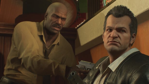 Un homme noir brandit une arme sur Frank West, le héro de Dead Rising, tandis que ce dernier regard ailleurs.